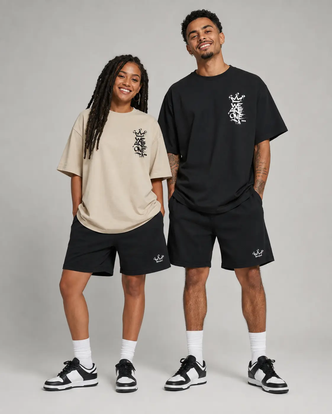 Deux modèles de face portant les t-shirts WE ARE ONE noir et beige